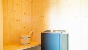 A sauna room with wooden walls, a wooden bench, and a blue sauna bench. - Grossenbrode Meeresflucht (Grossenbrode)