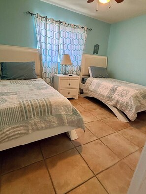 A bedroom with two beds, a nightstand, a lamp, and a wall clock. - Private pool home a bike ride to Siesta Key beach (Siesta Key)