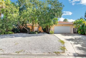 A residential property with a garage, driveway, and surrounding vegetation. - Private pool home a bike ride to Siesta Key beach (Siesta Key)