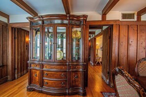 A traditional wooden cabinet with glass doors, a wooden floor, and a wooden ceiling with exposed beams. - Historic Charm: Spacious Home w/ Fenced Yard - 3BR/2BA Near Downtown (St. Augustine)