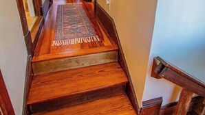 Eine Holztreppe mit Teppich, der zu einem Raum führt.