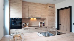Een moderne keuken met houten kastjes, een roestvrijstalen spoelbak en een ingebouwde oven.