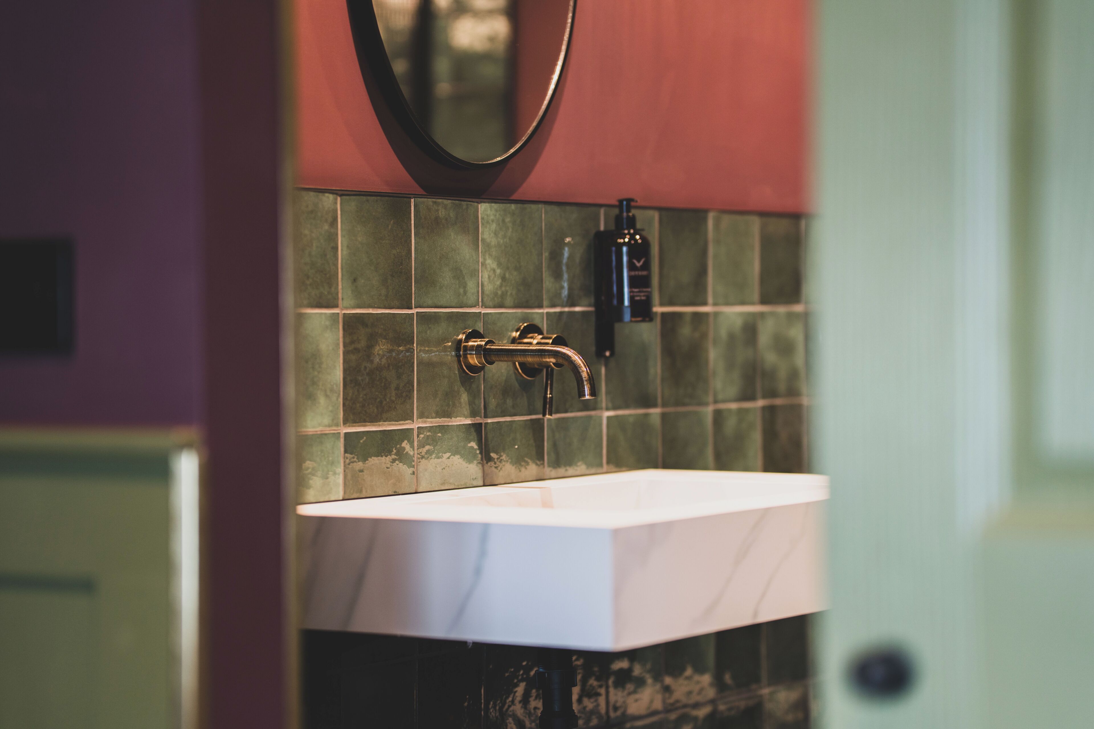 A bathroom with a white sink, a mirror, and a shower area.