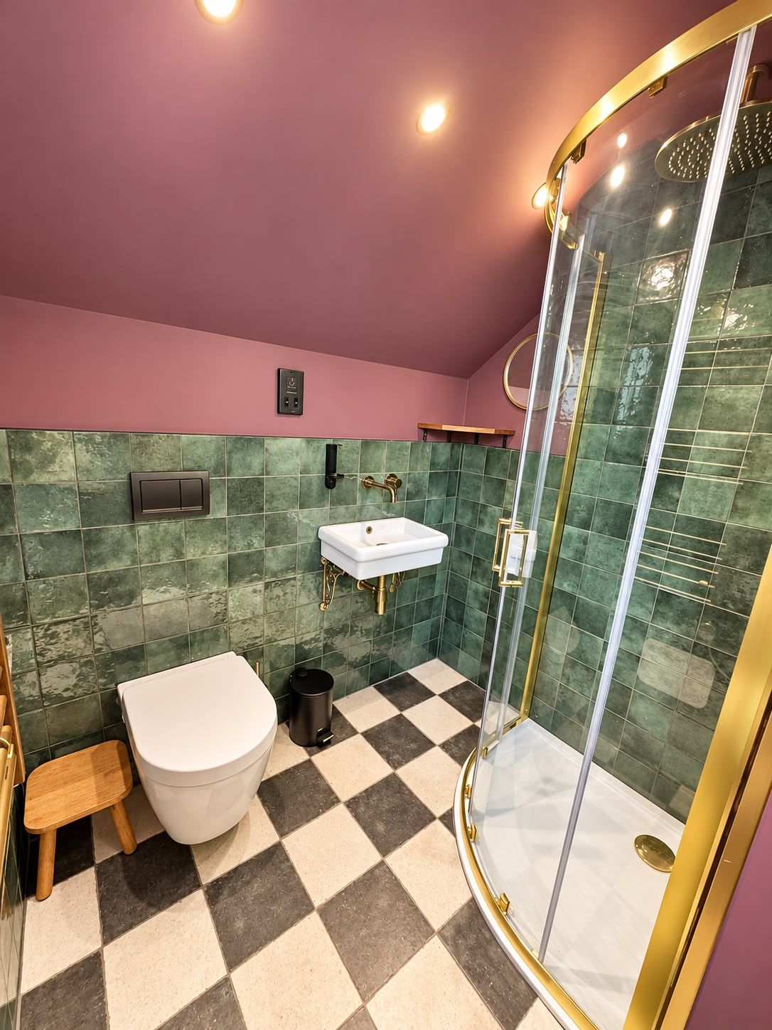 Un baño con piso de cuadros, inodoro blanco, lavamanos y ducha con cerramiento de vidrio.