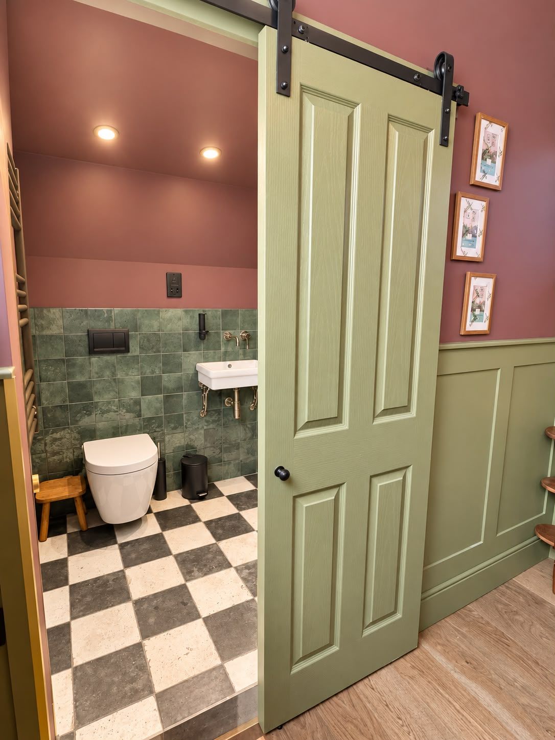 Un baño con piso a cuadros, inodoro, lavamanos y una puerta.