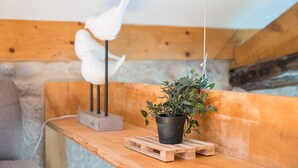 Eine Holzbank mit hängender Pflanze und einer weißen Skulptur.