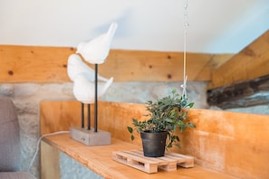 Eine Holzbank mit hängender Pflanze und einer weißen Skulptur.