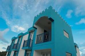 Ein mehrstöckiges Gebäude mit Balkonen und einer blauen Fassade.