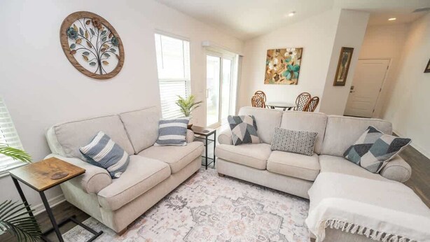 Ein Wohnzimmer mit zwei Sofas, einem Couchtisch und einem Teppich.