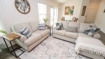 A living room with two sofas, a coffee table, and a rug.