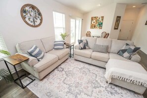 A living room with two sofas, a coffee table, and a rug.