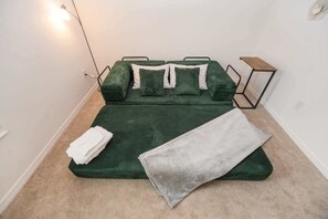 A bed with a green cover, a grey blanket, and white pillows. - 5 minutes to EastPort, Life Style ID's! (Sumterville)