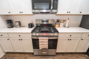 A kitchen with a stainless steel stove, a microwave above it, and a coffee maker on the counter. - 5 minutes to EastPort, Life Style ID's! (Sumterville)