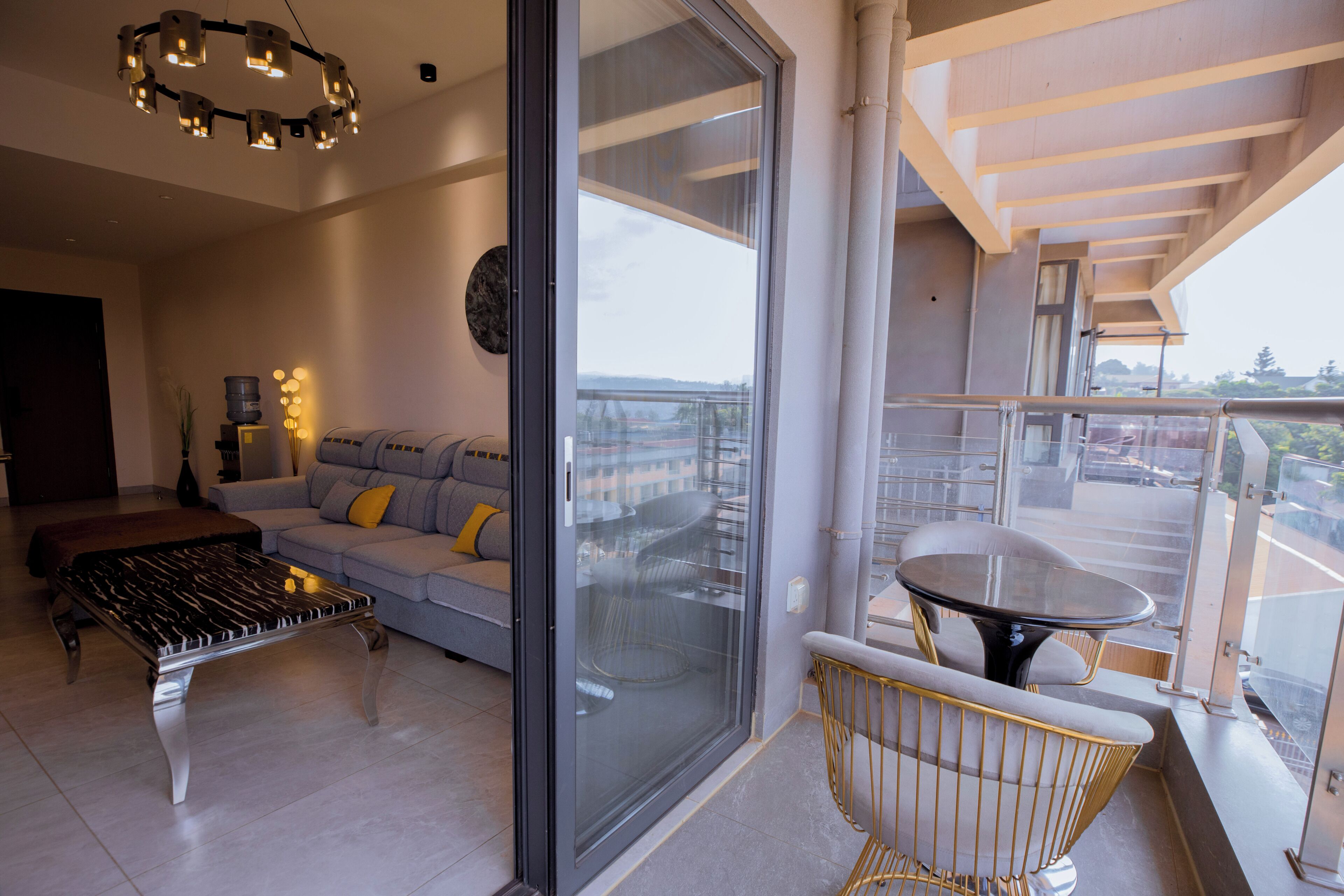 Een moderne woonkamer met een bank, een salontafel, en een balkon met een tafel en stoelen.