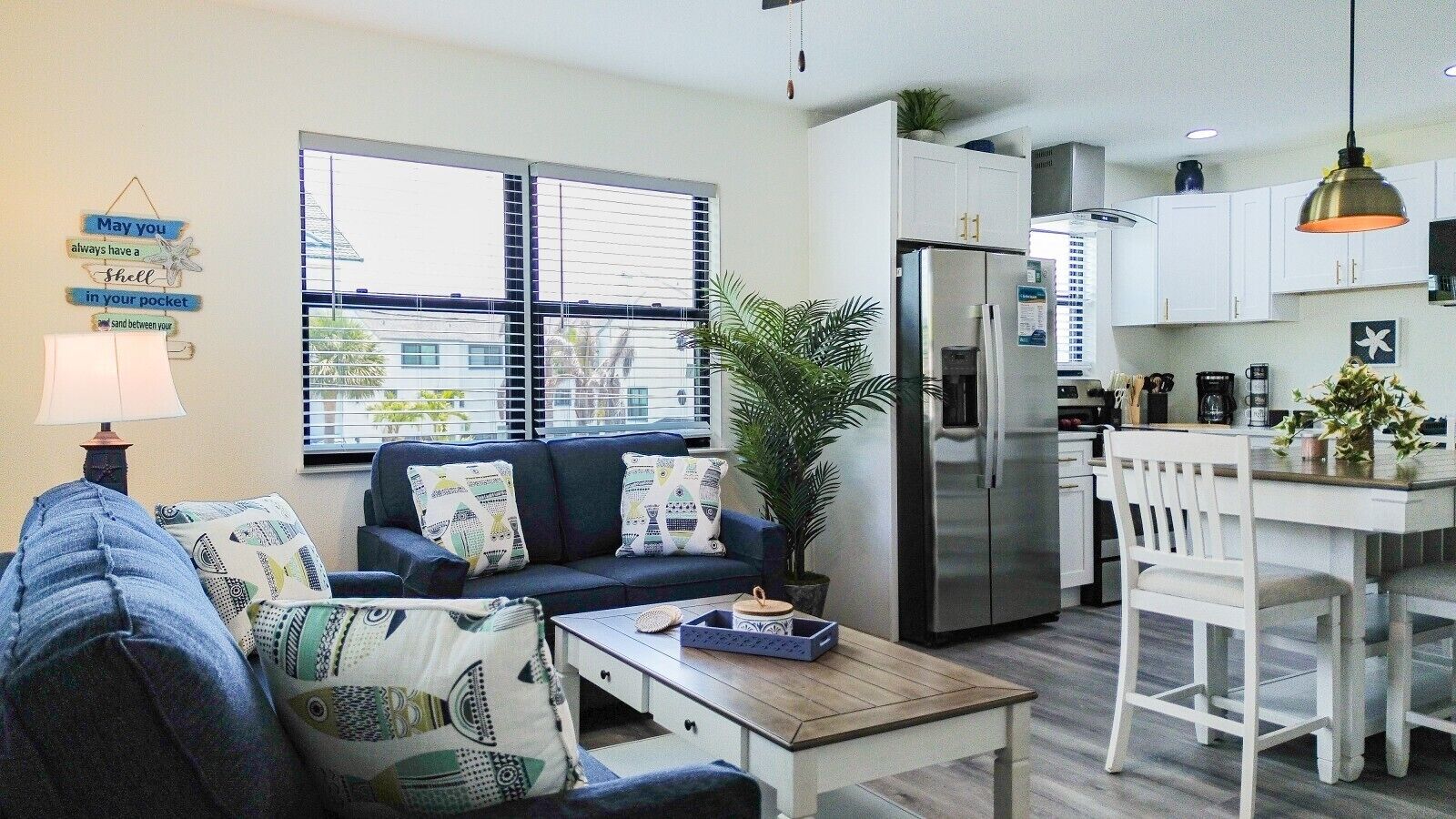 A modern living room with a sofa, coffee table, and a dining area with a table and chairs.