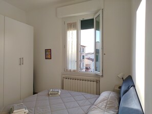 A bedroom with a bed, a radiator, a window, and a wardrobe. - Very bright apartment, a 15-minute walk from the historic center - AC - Wi-Fi (Firenze)