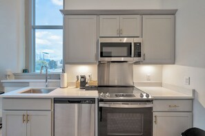 Eine moderne Küche mit Edelstahlgeräten, einem Geschirrspüler und einem eingebauten Backofen.
