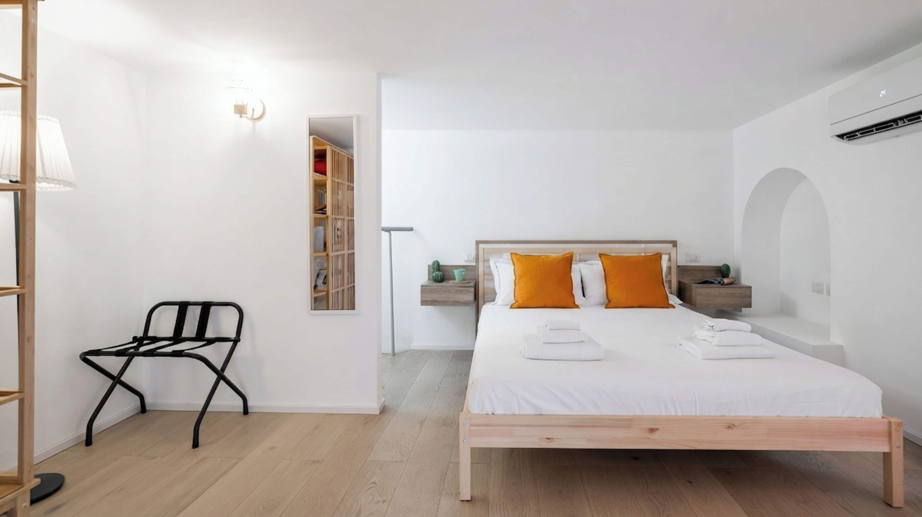 Une chambre à coucher comprenant un lit, une chaise, une table de chevet et une armoire.