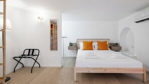 Un dormitorio con cama, una silla, mesita de noche y armario.