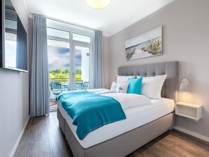 A modern hotel room with a large bed, a balcony with outdoor seating, and a painting on the wall. - Parkside Retreat in der Nahe von Baltic (Lübeck)
