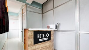 Una recepción de hotel con un cartel que indica servicio de empresa.