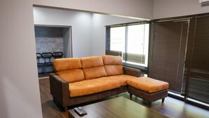 A modern living room with a sectional sofa, a coffee table, and a seating area with chairs.