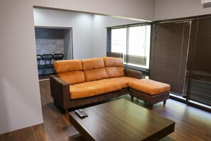 A modern living room with a sectional sofa, a coffee table, and a seating area with chairs.