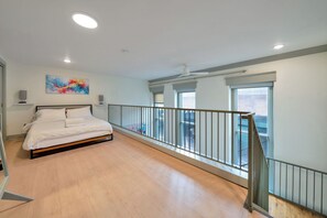A bedroom with a bed, a painting, a window, and a balcony railing. - Creative Loft - Nearby Parking - City Center - 2F (Louisville)