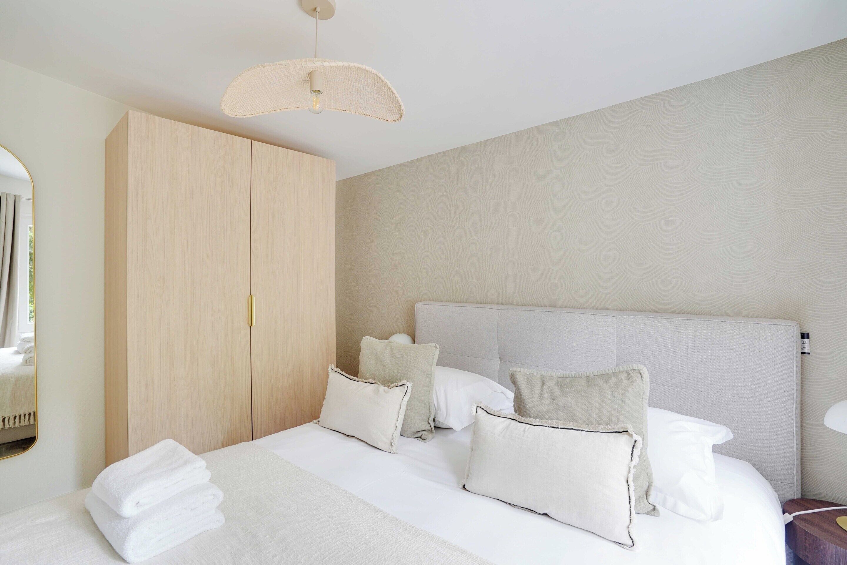 Een hotelkamer met een groot bed, een kledingkast en een spiegel.
