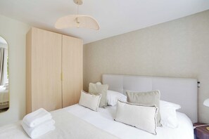 A hotel room with a large bed, a wardrobe, and a mirror. - Charming House -2br-4p- Ivry-sur-seine (Ivry-sur-Seine)
