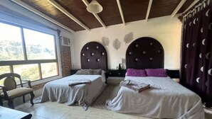 Un dormitorio con dos camas, una ventana y vistas al exterior.