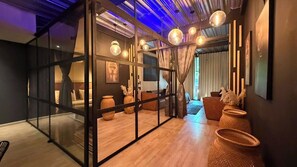 A modern interior with a glass partition, wooden flooring, and hanging spherical light fixtures. - Luxury mirror Provenza (Medellín)
