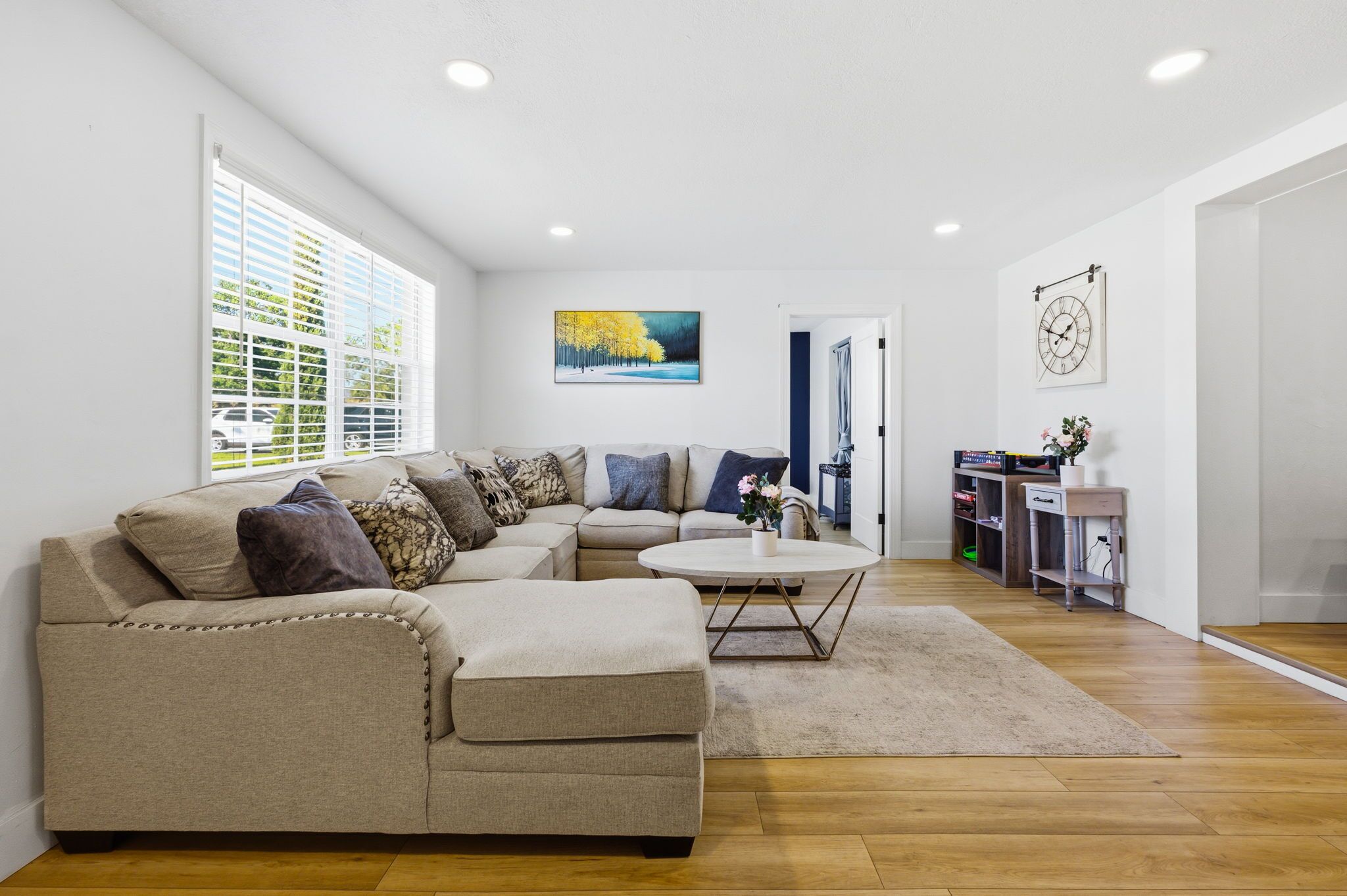 A living room with a sofa, coffee table, and artwork on the walls.