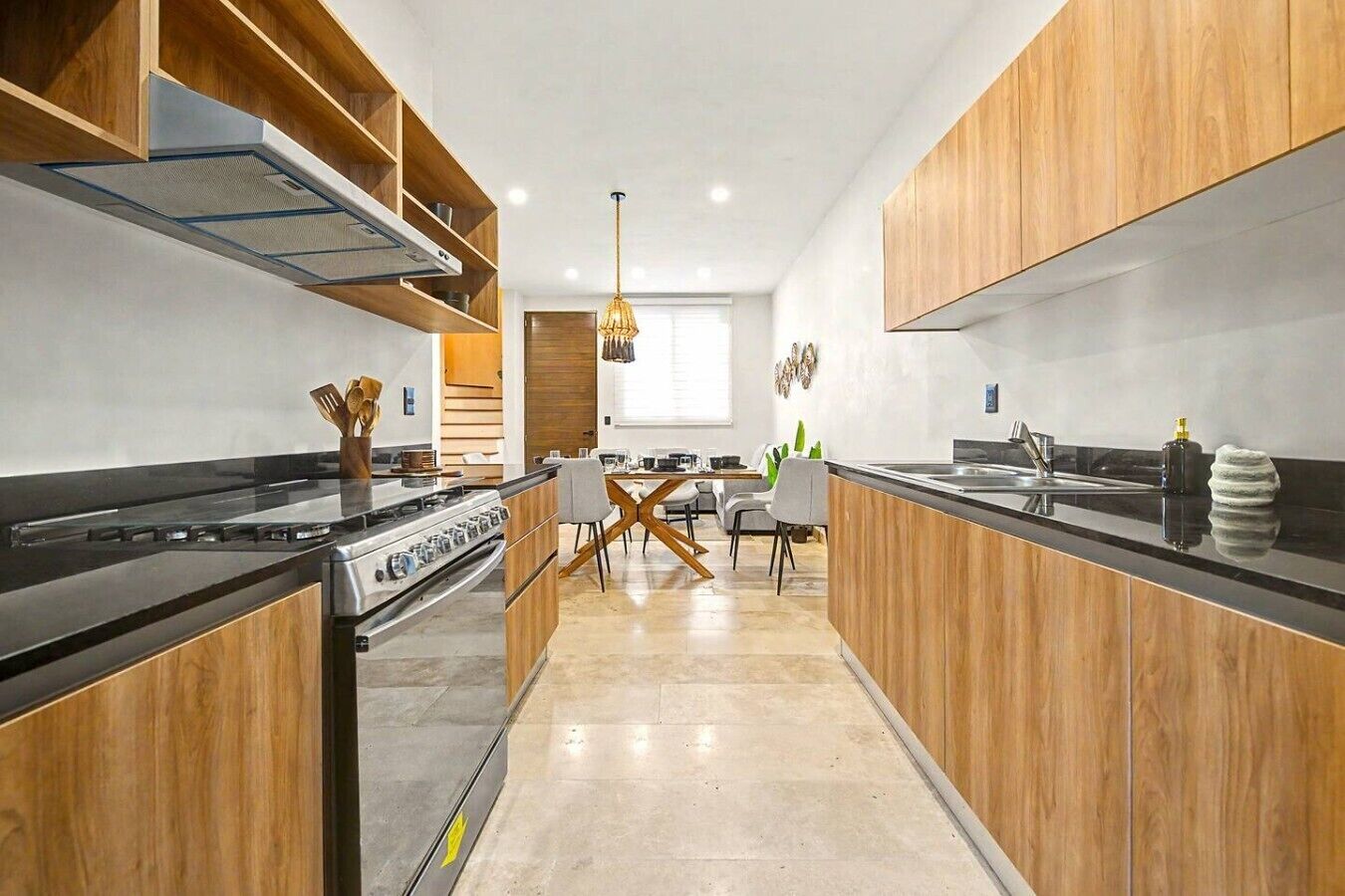 Una cucina moderna con isola centrale, mobili in legno e zona pranzo con sedie dal design contemporaneo.