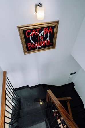 Una escalera con barandilla y un cartel en la pared que dice 'CAT IS BEAUTIFUL'.