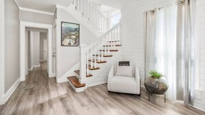 A staircase with white railings and wooden steps leading to a landing. - Fresh and Cozy Mansion Near Downtown (Kansas City)