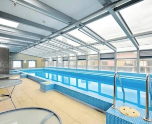 A swimming pool with a tiled deck, metal railings, and a glass ceiling. - Minimal at Altitude Poolside Stay by CBD Landmarks (Melbourne)