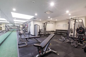 A gym with various exercise equipment, including benches, dumbbells, and weight machines. - La Trobe Lookout Poolside Retreat by State Library (Melbourne)