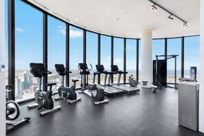 Ein modernes Fitnessstudio mit Cardiogeräten und Blick auf die Stadt.