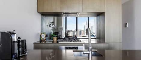 A modern kitchen with a stainless steel sink, a built-in stove, and wooden cabinets.