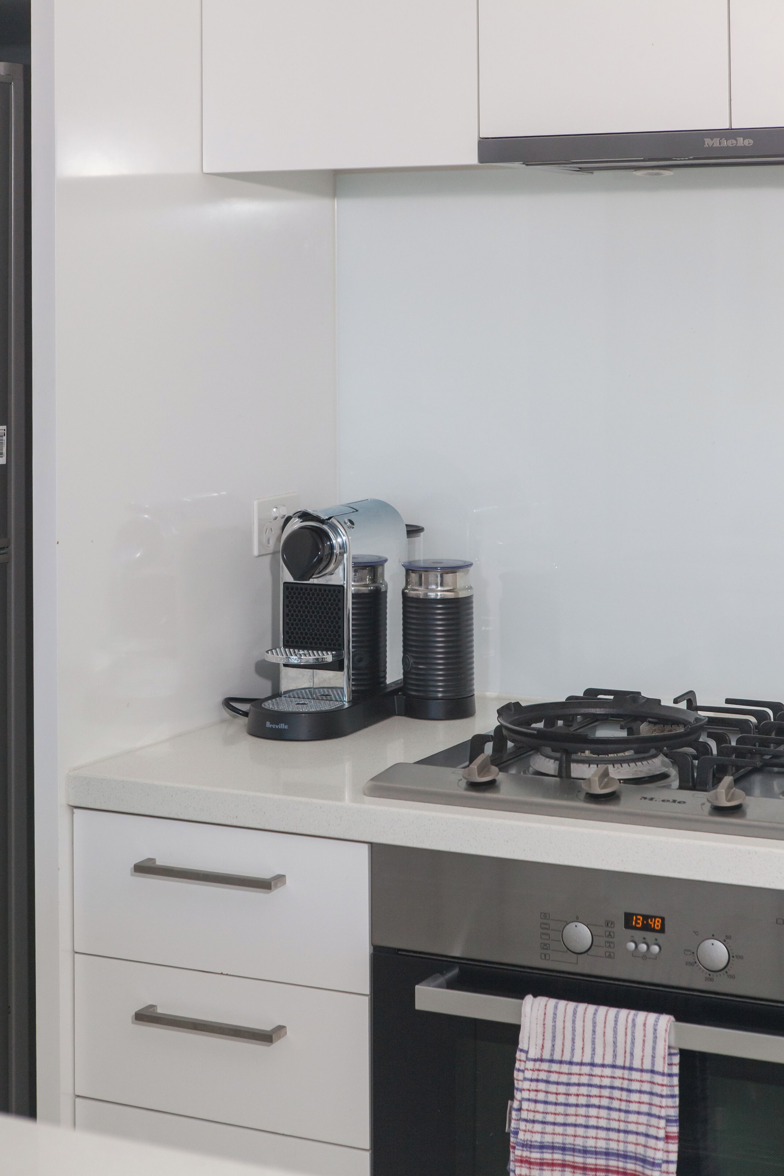 A kitchen with a coffee maker, a gas stove, and a microwave.