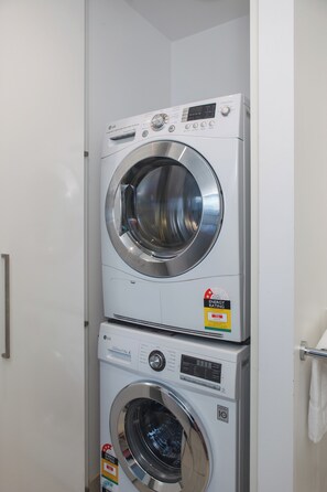 A stacked washer and dryer unit with energy efficiency labels. - Yarra Vista Riverside City Escape by Crown Casino (Southbank)