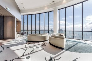A modern interior with large windows, a curved seating area, and a view of the cityscape. - Oriana Refined Skyline Retreat by Yarra River (Southbank)