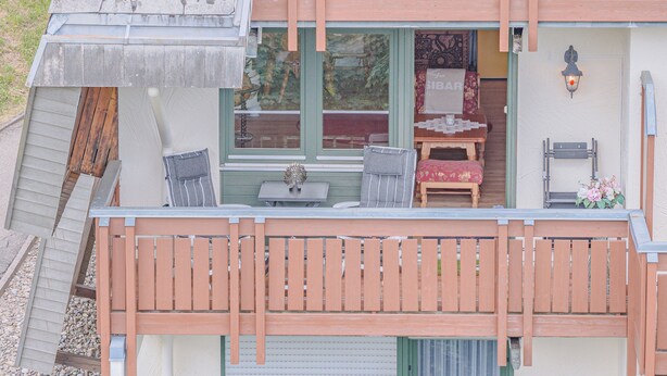 A two-story building with a balcony, a small table, and a chair. - View of Todtmoos with a Panoramic Balcony – My SWH (Todtmoos)