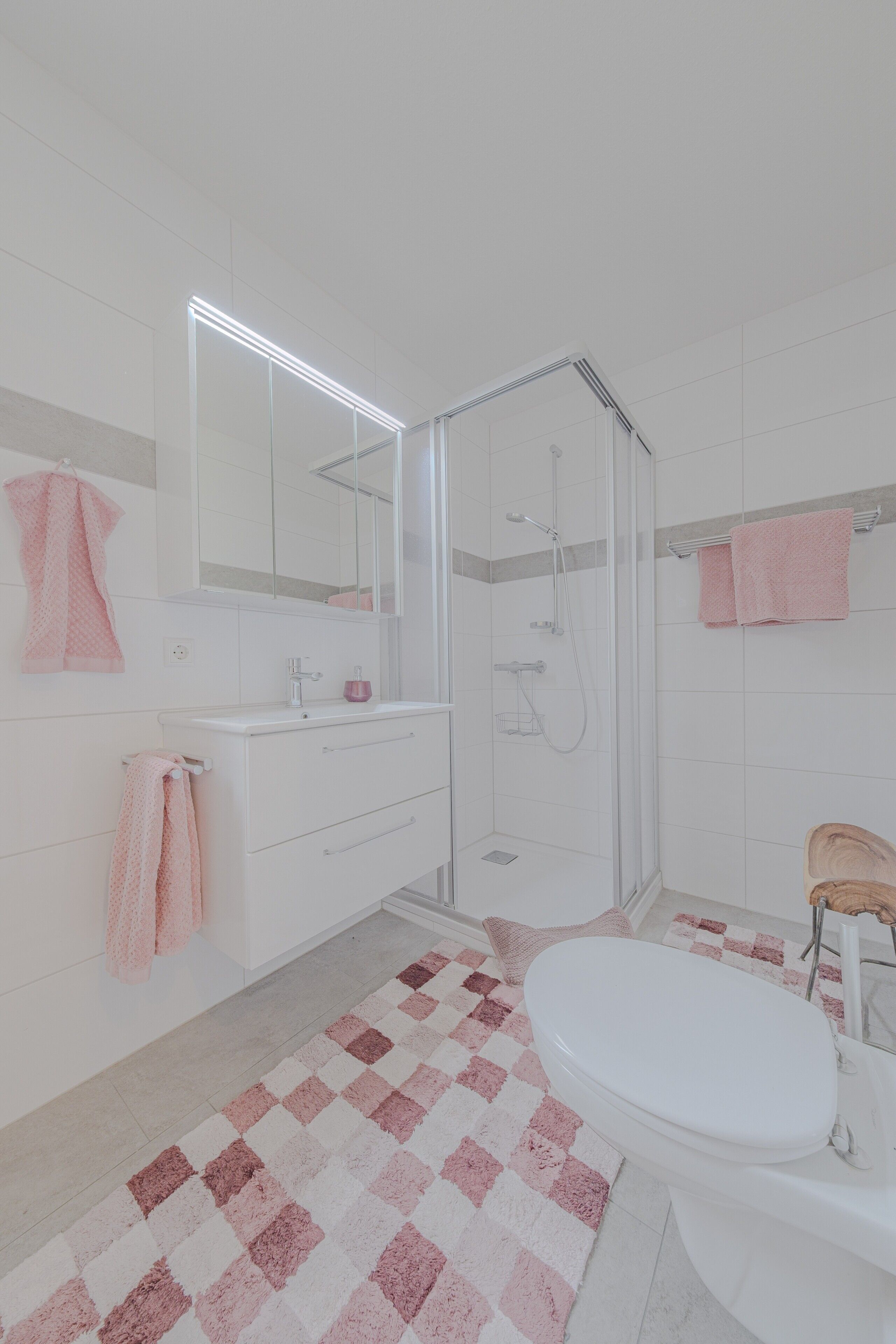 Een badkamer met een douche, een wastafel en toilet.