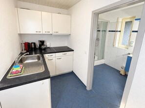 A compact kitchen with a sink, countertop, and cabinets. - Pine Forest Bliss – A Wonderful Vacation with a Stunning Balcony View – My Little Black Forest Cottage (Todtmoos)