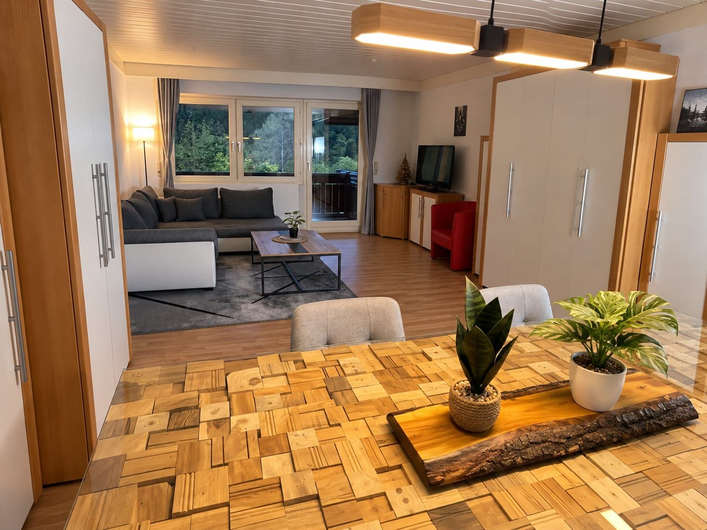 Un salon moderne comprenant un canapé, une table basse et un coin repas avec une table et des chaises en bois.