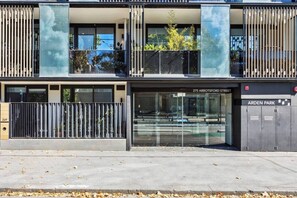 A modern building with a glass facade, a gated entrance, and a sign for 'Arden Park.' - Vyra at Arden Park Minutes to Dining Shops and CBD (North Melbourne)