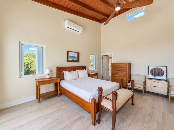 A bedroom with a wooden bed, bedside tables, a dresser, and a chair.