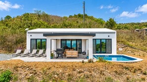 A modern house with a pool, outdoor seating, and a view of the sea. - Sunset Sea-Clusion | Private Pool & Ocean Views (Frederiksted)